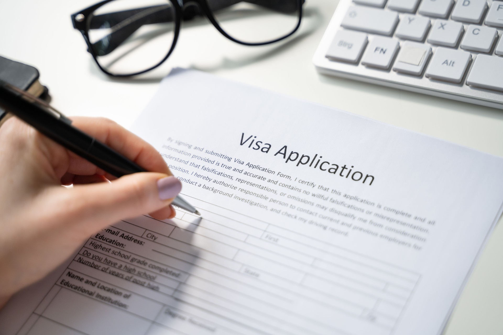 Person Hand Filling Visa Application Form